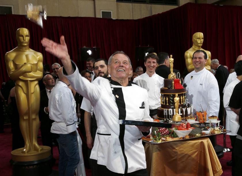 Celebrity chef Wolfgang Puck tosses one of his 2014 Oscars creations to the crowd as he shows them off with his teammates at the 86th Academy Awards in Hollywood, California March 2, 2014. u00e2u20acu201d Reuters pic