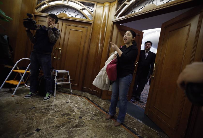 A woman shouts to journalists, in front of a hotel in Beijing, March 14, 2014, asking not to take pictures of families of passengers aboard a missing Malaysia Airlines plane MH370. u00e2u20acu201d Reuters pic