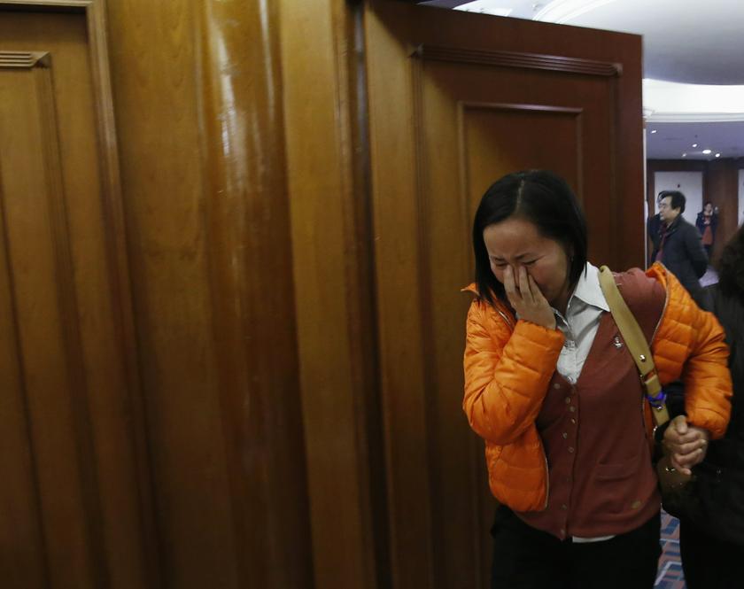 A woman cries as she walks out of a room for relatives or friends of passengers aboard the missing Malaysia Airlines flight MH370, at a hotel in Beijing, March 14, 2014.