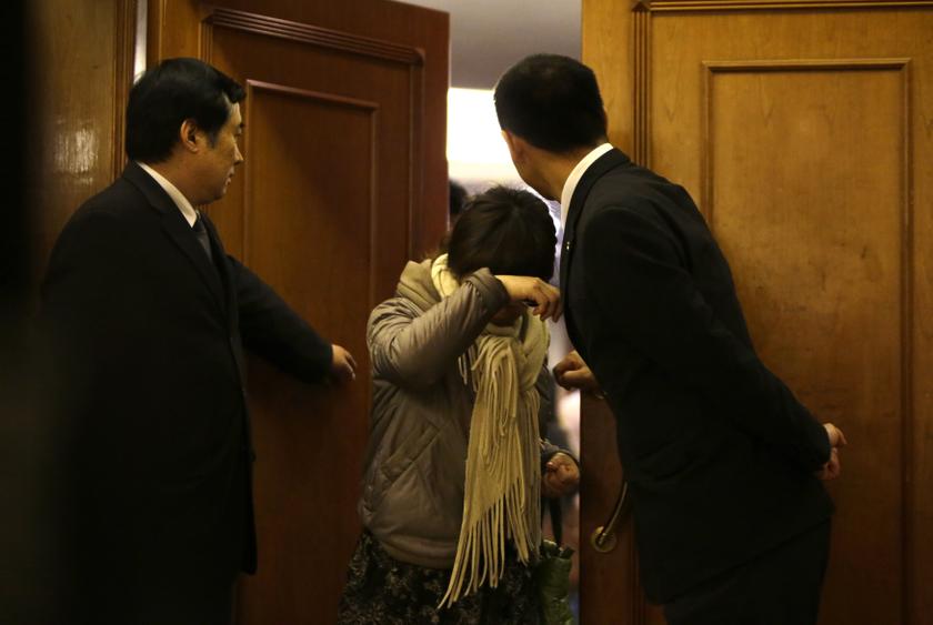 A family member of a passenger shields herself from journalists as she exits a rest area for relatives of passengers of Malaysia Airlines flight MH370, after a morning meeting at Lido Hotel in Beijing, March 12, 2014. u00e2u20acu201d Reuters pic