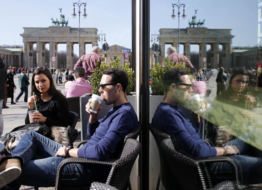 Tourists are reflected in a coffee shop window as they sit outside enjoying the sunshine in front of the Brandenburg Gate in Berlin March 20, 2014. u00e2u20acu201d Reuters pic