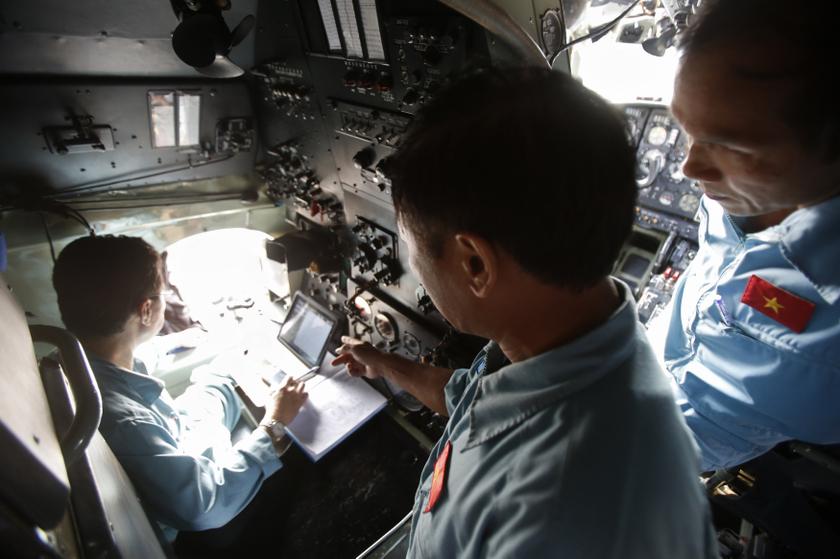 Military officers Phung Truong Son (left), Vu Duc Long (centre) and Pham Minh Tuan discuss a map of a search area before their departure to find the missing Malaysia Airlines flight MH370, at a military airport in Ho Chi Minh city March 14, 2014. u00e2u20acu201d Reut