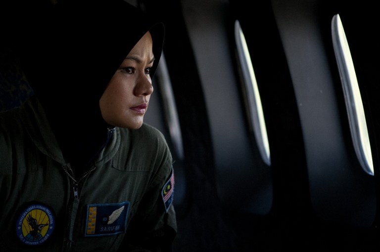A crew member looks out the windows from a Malaysian Air Force CN235 aircraft during a search and rescue operation to find the missing MH370 over the Straits of Malacca on March 15, 2014. u00e2u20acu201d AFP pic