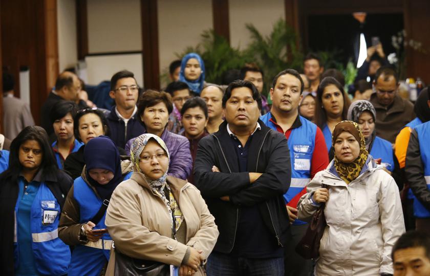 Members of a Malaysia Airlines special assistance team watch as Malaysian Prime Minister Najib Razak's news conference streamed live on a projector screen at a hotel in Beijing March 15, 2014. u00e2u20acu201d Reuters pic
