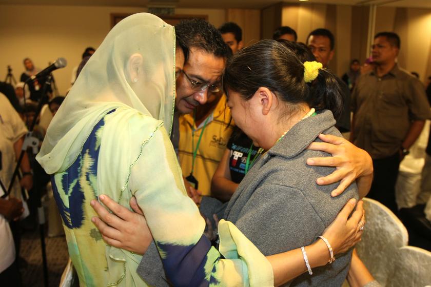 Acting Transport Minister Datuk Seri Hishammuddin Hussein hugs the family member of a passenger on board the missing MAS flight MH370 at the Everly Hotel in Putrajaya, on March 29, 2014. 