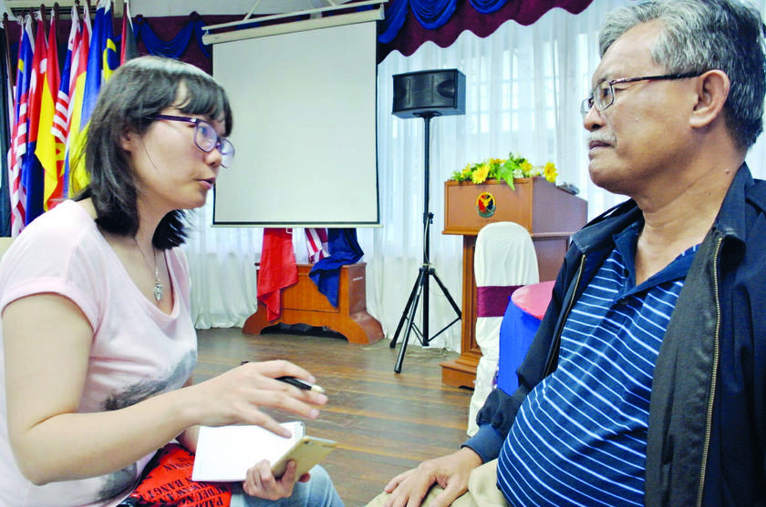 Huang talks to a senior MMEA officer at the agency media room in Tok Bali. 