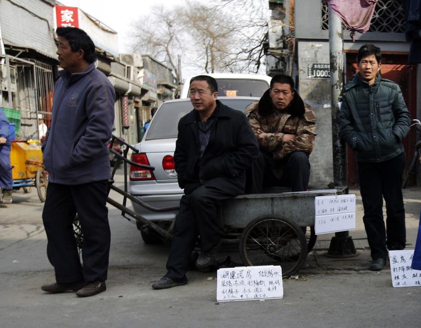 Jobseekers with signs mentioning their skills wait for employers at a market street in a Hutong, Chinese for 'small alley', in Beijing March 7, 2014. u00e2u20acu201d Reuters pic
