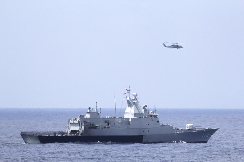 The Royal Malaysian Navy corvette KD Terengganu and a US Navy MH-60R Sea Hawk helicopter from the US Navy guided-missile destroyer USS Pinckney conduct a coordinated air and sea search for a missing Malaysian Airlines jet in the Gulf of Thailand March 12,