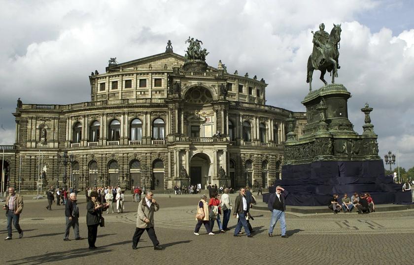 People walk past a statue of King Johann of Saxony (1801-73) in front of the Semperoper opera house in Dresden in this October 2, 2000 file photo.