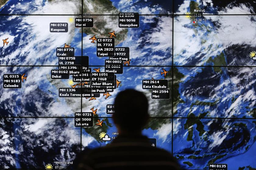 A man watches a large screen showing different flights at the departure hall of Kuala Lumpur International Airport March 13, 2014. u00e2u20acu201d Reuters pic