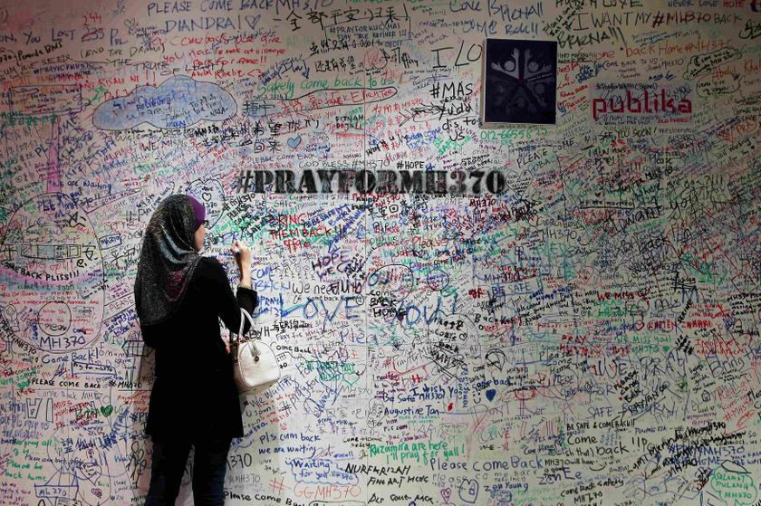 A woman writes on the message board in support of the passengers and family members of the missing Malaysia Airlines Flight MH370, at a shopping mall in Damansara near Kuala Lumpur March 21, 2014. u00e2u20acu201du00c2u00a0Reuters pic