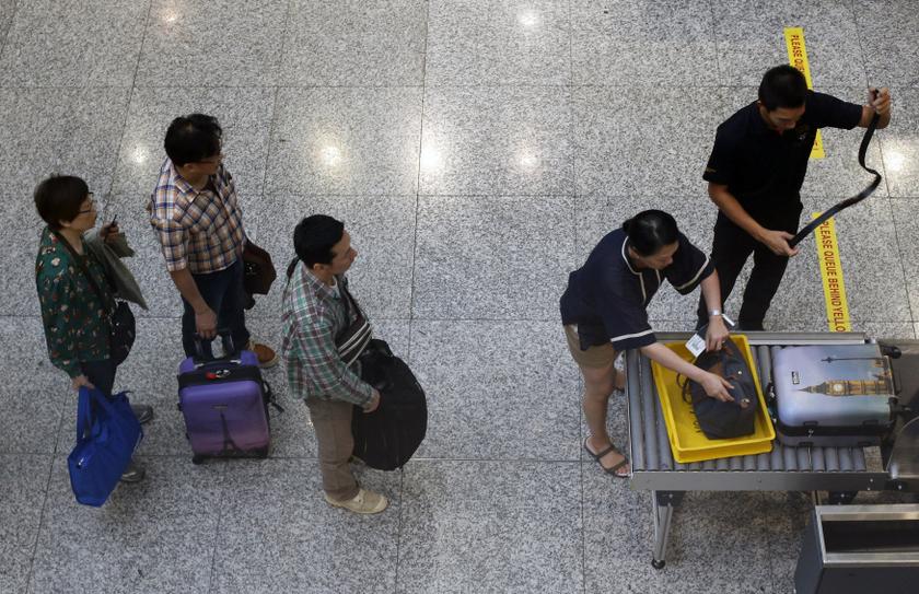 A passenger removes his belt as he puts his belongings into an X-ray machine for screening by airport security at the departure hall of the Kuala Lumpur International Airport March 16, 2014. u00e2u20acu201d Reuters pic