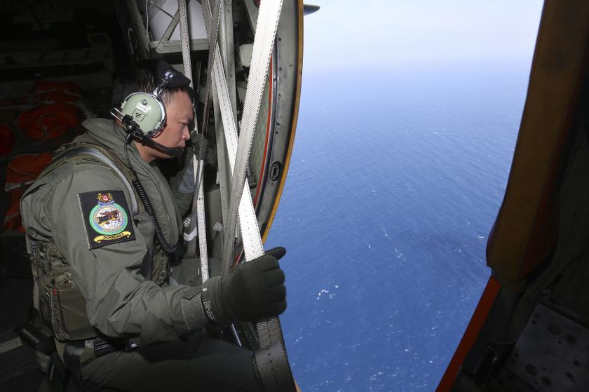 A member of the military personnel looks out of a Republic of Singapore Air Force C130 transport plane during the search for the missing Malaysia Airlines MH370 plane over the South China Sea March 11, 2014. u00e2u20acu201d Reuters pic