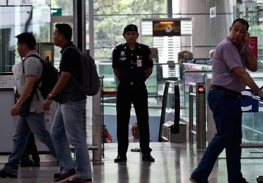A police officer (centre) stands guard at the departure hall of the Kuala Lumpur International Airport in Sepang on March 10, 2014. u00e2u20acu201d AFP pic