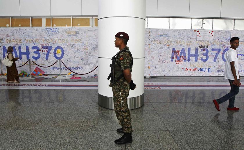 A Malaysian Army paratrooper stands between banners with messages expressing well wishes for passengers of the missing MH370, at the viewing gallery of the departure hall at Kuala Lumpur International Airport March 16, 2014. u00e2u20acu201d Reuters pic
