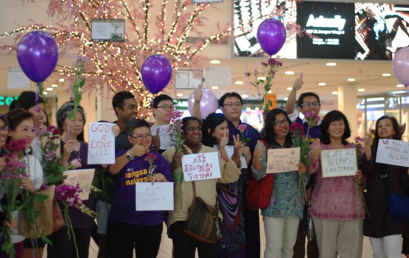 A small group holds purple balloons and placards with messages such as u00e2u20acu02dcGod is oneu00e2u20acu2122 and u00e2u20acu02dcWe are brothers and sistersu00e2u20acu2122 during the u00e2u20acu02dcFlashmob for Peaceu00e2u20acu2122 gathering in Kuala Lumpur March 5, 2014. u00e2u20acu201d Picture by Mohd Yusof Mat Isa
