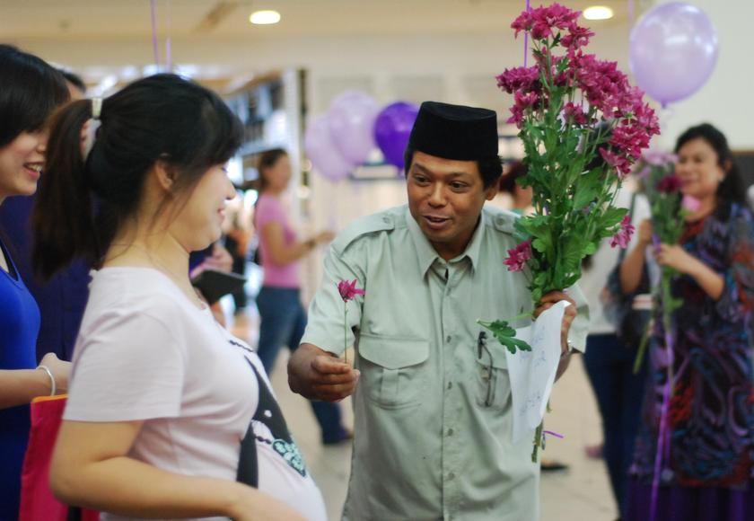 Ally Hazran Hashim from Kajang Solidarity gives a flower to a shopper during the u00e2u20acu02dcFlashmob for Peaceu00e2u20acu2122 gathering  in Kuala Lumpur March 5, 2014. u00e2u20acu201d Picture by Mohd Yusof Mat Isa