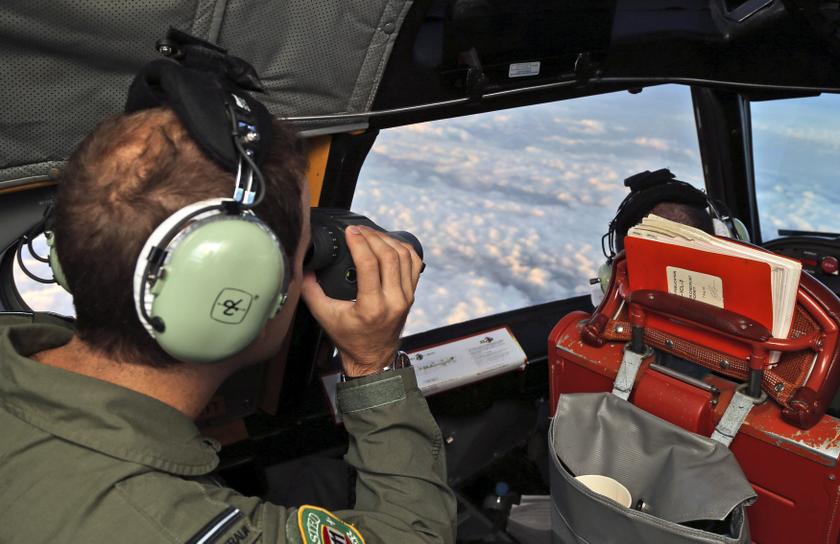 A crew member aboard a Royal Australian Air Force (RAAF) AP-3C Orion uses binoculars as it flies over the southern Indian Ocean during the search for missing Malaysian Airlines flight MH370 March 22, 2014. u00e2u20acu201d Reuters pic