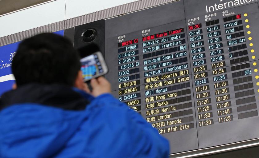 A man takes pictures of a flight information board displaying the Scheduled Time of Arrival (STA) of Malaysia Airlines flight MH370 (top, in red) at the Beijing Capital International Airport in Beijing, March 8, 2014. u00e2u20acu201d Reuters pic