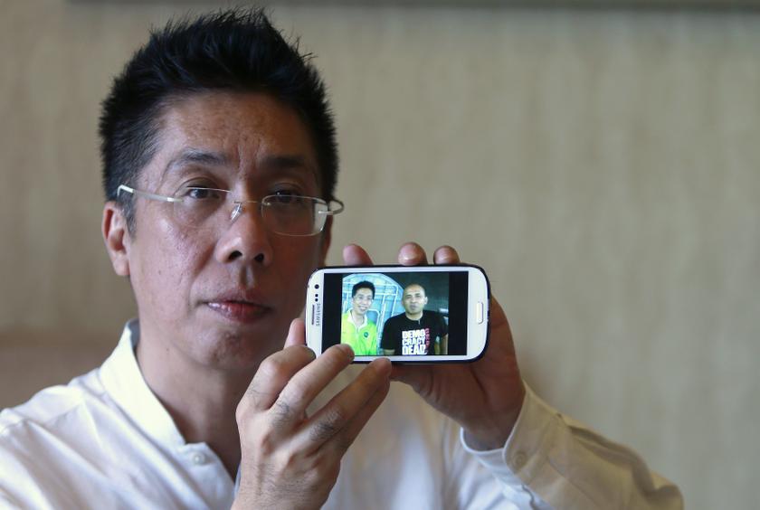 Peter Chong holds up his smartphone to show a photo of himself with missing Malaysia Airlines Flight MH370 captain Zaharie Ahmad Shah at a hotel in Sepang March 18, 2014. — Reuters pic