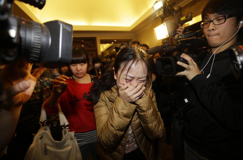 A relative (front) of a passenger of Malaysia Airlines flight MH370 cries as she walks past journalists at a hotel in Beijing March 9, 2014. — Reuters pic