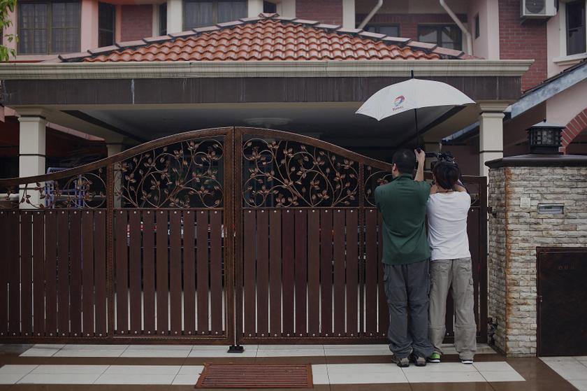 A journalist films the home of Malaysia Airlines flight MH370 co-pilot Fariq Abdul Hamid in Shah Alam, near Kuala Lumpur March 16, 2014. u00e2u20acu201d Reuters pic