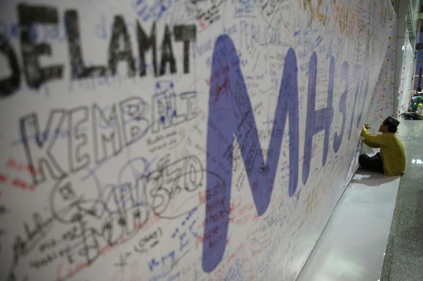 A man writing a message of support for the passengers and families of the missing MH370 at the viewing gallery in KLIA, on March 13, 2014. — Picture by Choo Choo May