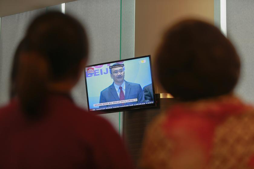Journalists look at a TV screen broadcasting a news conference on the missing Malaysia Airlines flight MH370, inside the hotel where are relatives of the passengers of the missing Boeing 777-200ER are staying in Putrajaya March 20, 2014. u00e2u20acu201d Reuters pic