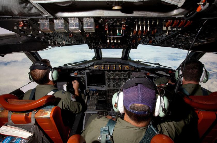 Co-Pilot Flying Officer Marc Smith (left) and crewmen fly at high altitude aboard a Royal Australian Air Force (RAAF) AP-3C Orion aircraft after searching for the missing Malaysian Airlines Flight MH370 over the southern Indian Ocean March 24, 2014. u00e2u20acu2022 R