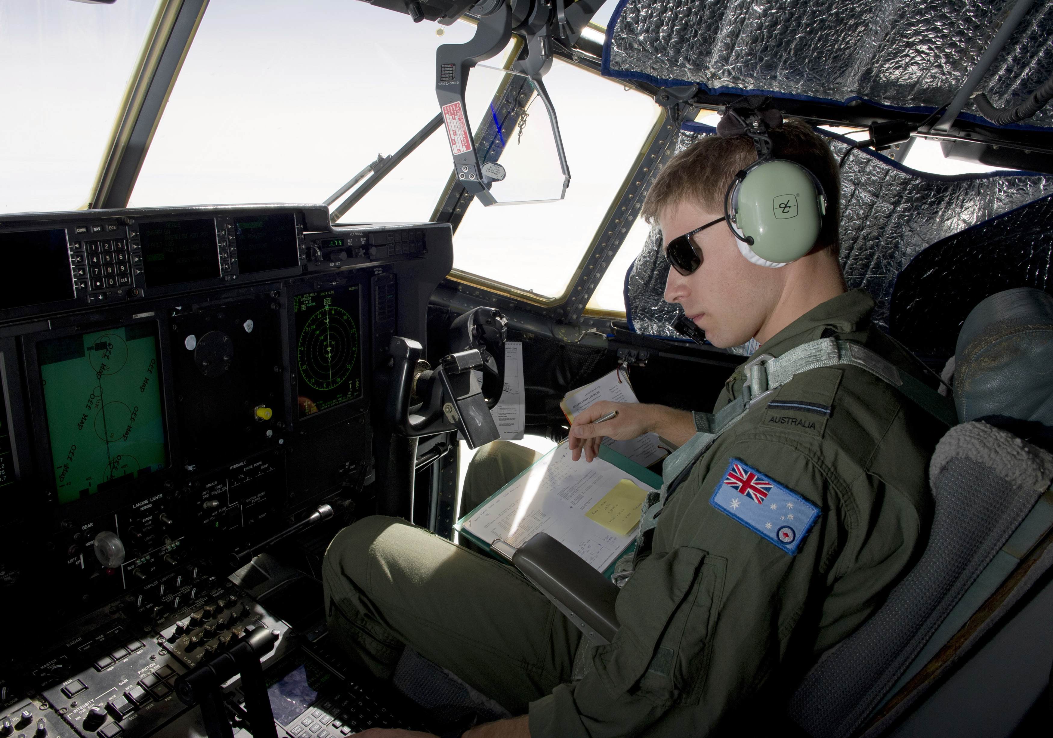 Royal Australian Air Force (RAAF) Pilot Flying Officer Sam Dudman monitors the systems of a RAAF C-130J Hercules aircraft as it prepares to launch two Self Locating Data Marker Buoys in the southern Indian Ocean during the search for missing Malaysian Air