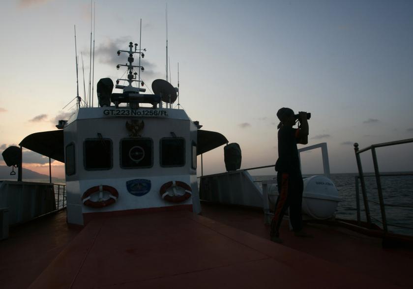 A member of a rescue team looks through binoculars during a search and rescue operation to find the missing Malaysia Airlines Flight MH370, in the Straits of Malacca March 14, 2014. u00e2u20acu201d Reuters pic