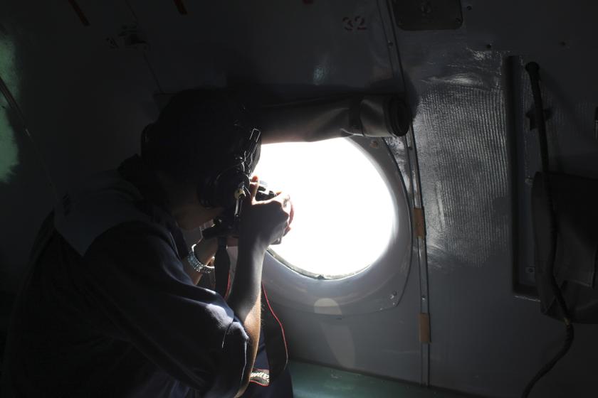 A Vietnamese Air Force officer takes photos from a search and rescue aircraft in the search area for a missing Malaysia Airlines plane, 250km from Vietnam and 190km from Malaysia, in this handout photo from Thanh Nien Newpaper taken March 8, 2014. u00e2u20acu201d Reu