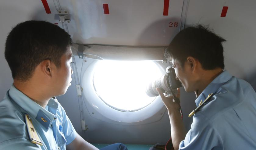 A military personnel takes photos from the window of an aircraft belonging to the Vietnamese airforce during a search and rescue mission off Vietnamu00e2u20acu2122s Tho Chu island March 10, 2014. u00e2u20acu201d Reuters pic