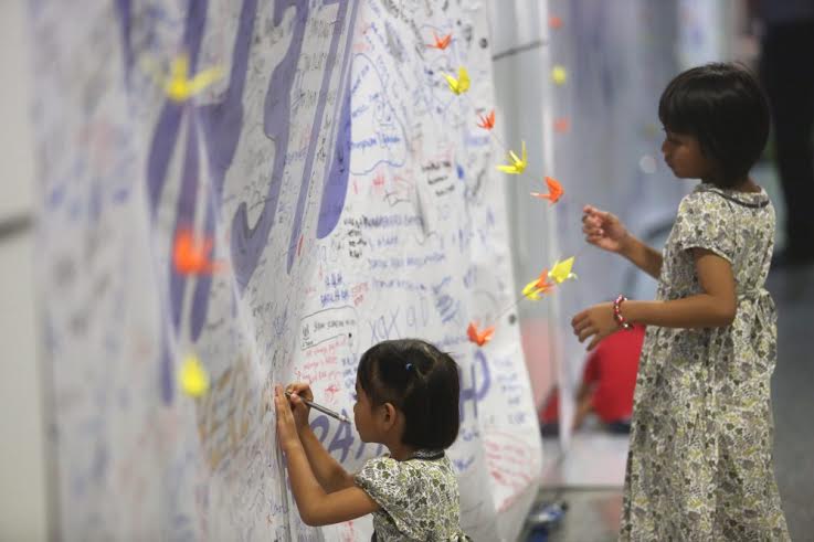 Two girls writing their message at the viewing gallery in KLIA. — Picture by Choo Choo May