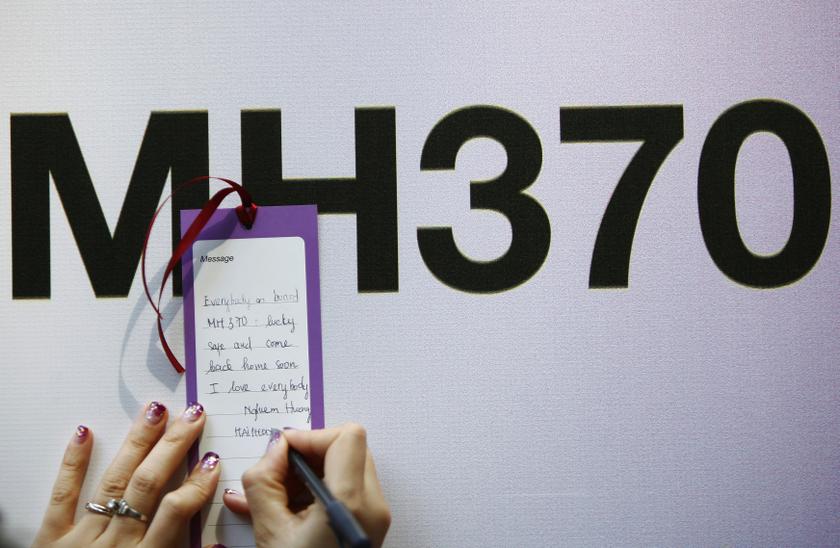 A tourist from Vietnam writes a message expressing hope for family members and those onboard the missing Malaysia Airlines flight MH370, in Kuala Lumpur March 12, 2014. u00e2u20acu201d Reuters pic