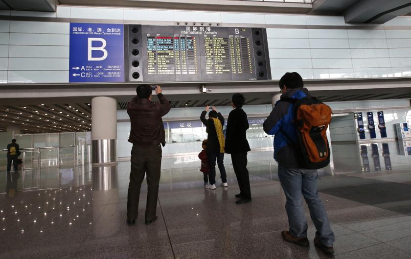 People take pictures of a flight information board displaying the Scheduled Time of Arrival of Malaysia Airlines flight MH370 (top, in red) at the Beijing Capital International Airport in Beijing, March 8, 2014.u00c2u00a0u00e2u20acu201d Reuters pic