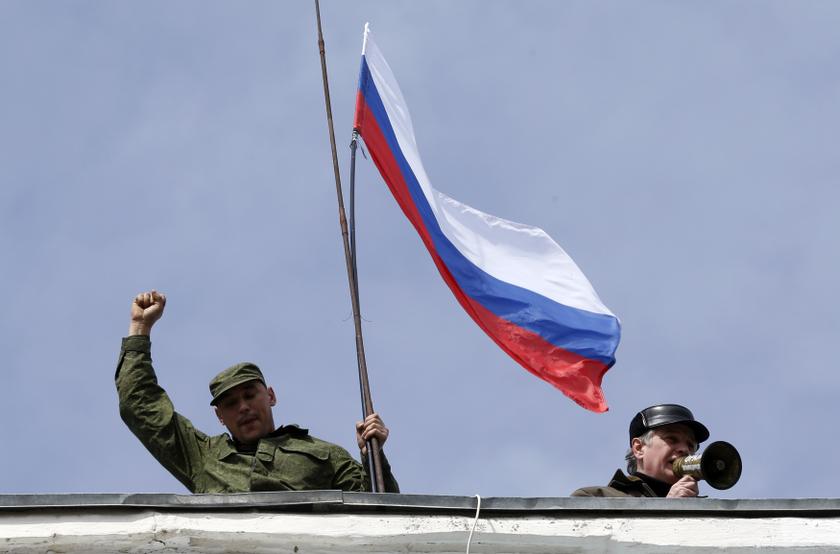 A man holds a Russian flag on the roof of the naval headquarters in Sevastopol, March 19, 2014. u00e2u20acu201d Reuters pic