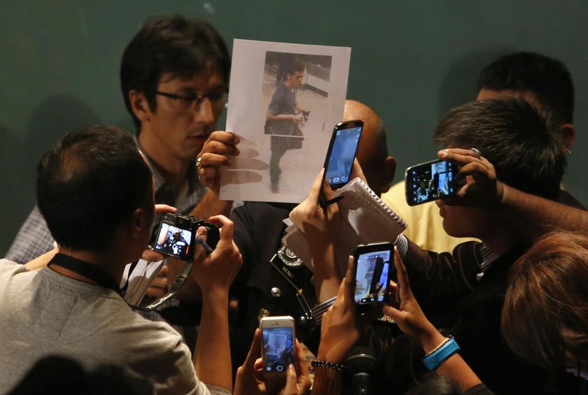 A journalist holds up a photo of one of the two men whom the Malaysian police believe were travelling on board the missing Malaysia Airlines MH370 on stolen passports after a news conference at KLIA on March 11, 2014. u00e2u20acu201d Reuters pic