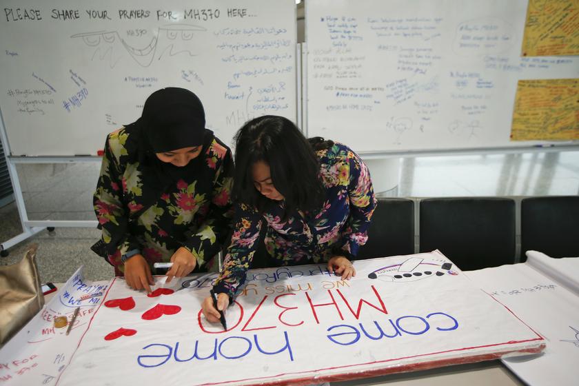 Women put the final touches to a sign of support and hope for the passengers of the missing Malaysia Airlines flight MH370 they made and brought to the Kuala Lumpur International Airport March 11, 2014.u00c2u00a0u00e2u20acu201du00c2u00a0Reuters pic