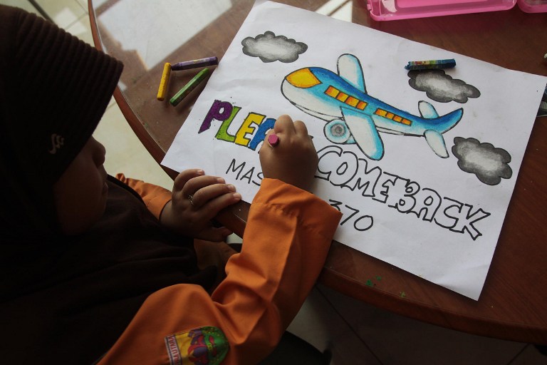  An Indonesian student writes a message expressing prayers and well-wishes for passengers onboard missing Malaysia Airlines flight MH370 in Medan, North Sumatra, on March 15, 2014. u00e2u20acu201d AFP pic