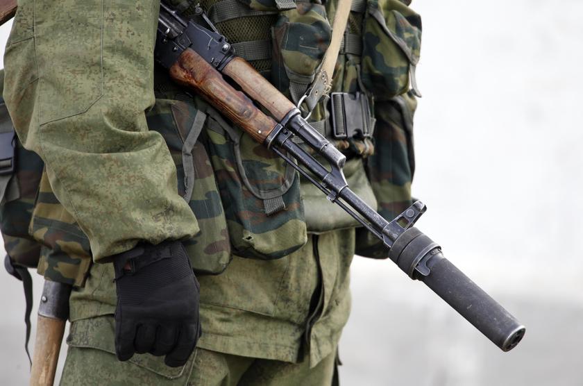 A uniformed man, believed to be a Russian serviceman, stands guard near a Ukrainian military base in the village of Perevalnoye outside Simferopol, March 6, 2014. Crimeau00e2u20acu2122s parliament voted to join Russia on March 6, 2014 and its Moscow-backed government