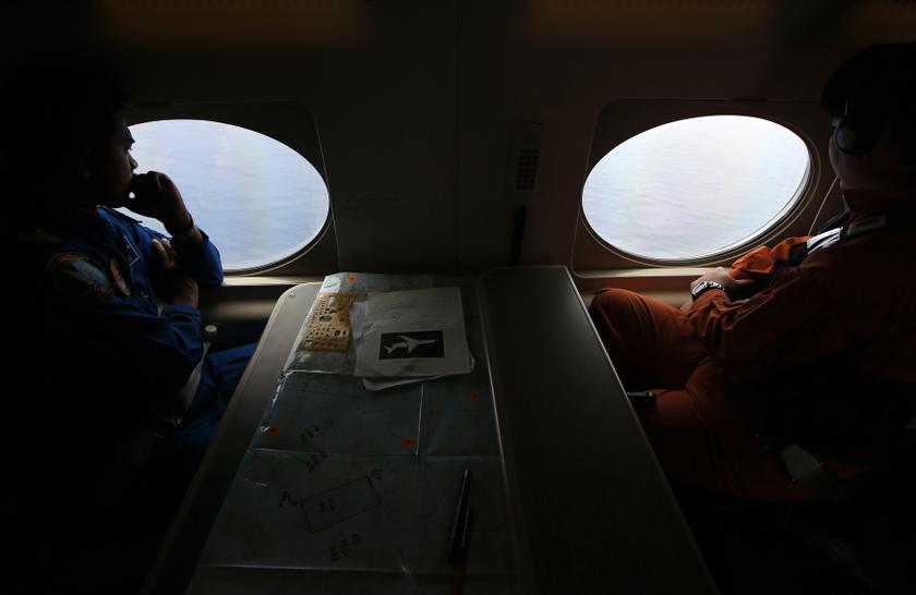 A Japan Coast Guard (JCG) officer (right) and a Malaysia Maritime Enforcement Agency pilot look out windows of JCG's Gulfstream V Jet aircraft, customized for search and rescue operations over the waters of the South China Sea March 15, 2014.u00c2u00a0u00e2u20acu201du00c2u00a0Reuter