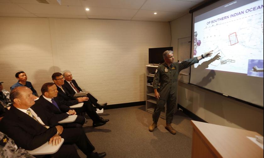 Australia's Prime Minister Tony Abbott (second left) is briefed on the search for Malaysia Airlines flight MH370 by Royal Australian Air Force Group Commander Craig Heap (right) during Abbott's visit to RAAF Base Pearce near Perth March 31, 2014. u00e2u20acu201d Reut