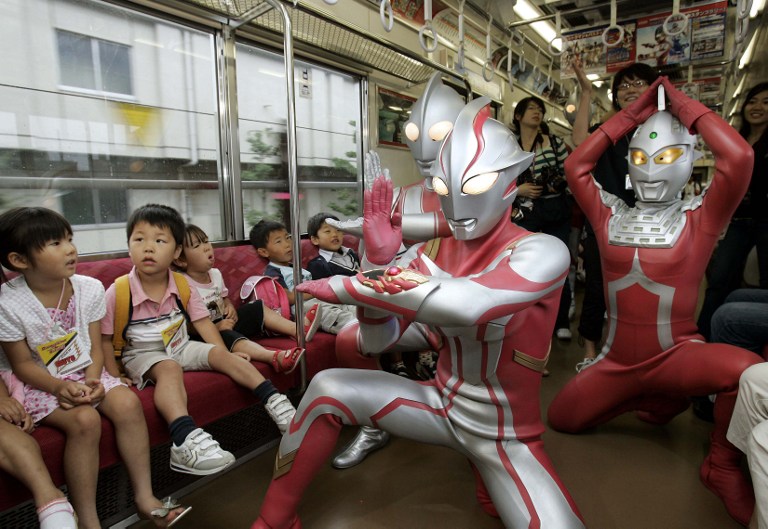 Ultra-heroes, Ultraman Mebius (centre), Ultraman Jack (left) and Ultraseven (right) pose next to children during a press preview inside a train in Tokyo, 17 July 2006. u00e2u20acu201d AFP pic