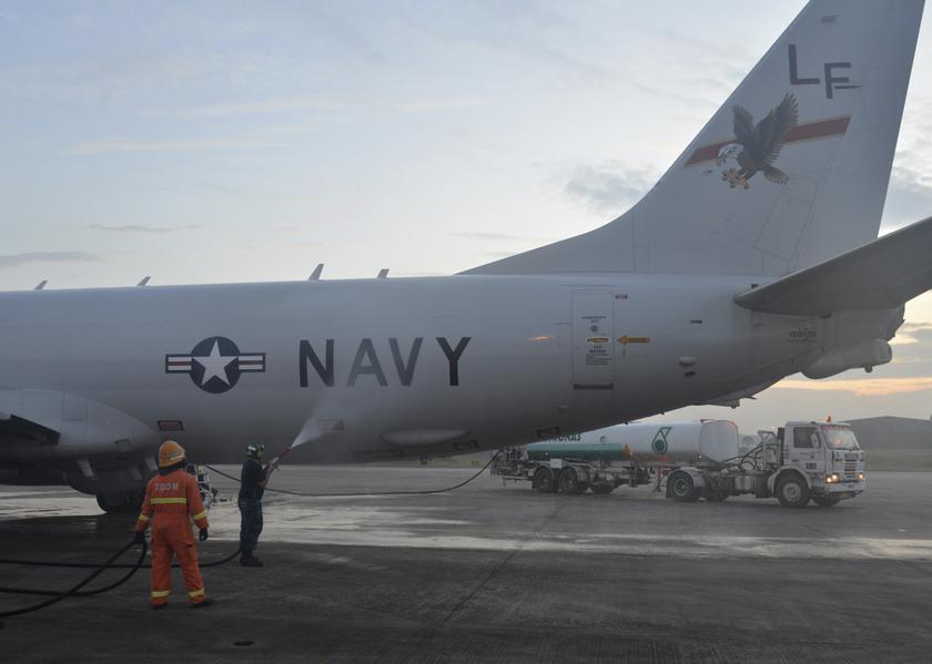 Aviation Structural Mechanic 2nd Class Matthew Walton sprays down a P-8A Poseidon with fresh water before its flight to assist in search and rescue operations for missing Malaysia Airlines flight MH370 in Kuala Lumpur March 18, 2014, in this U.S. Navy han
