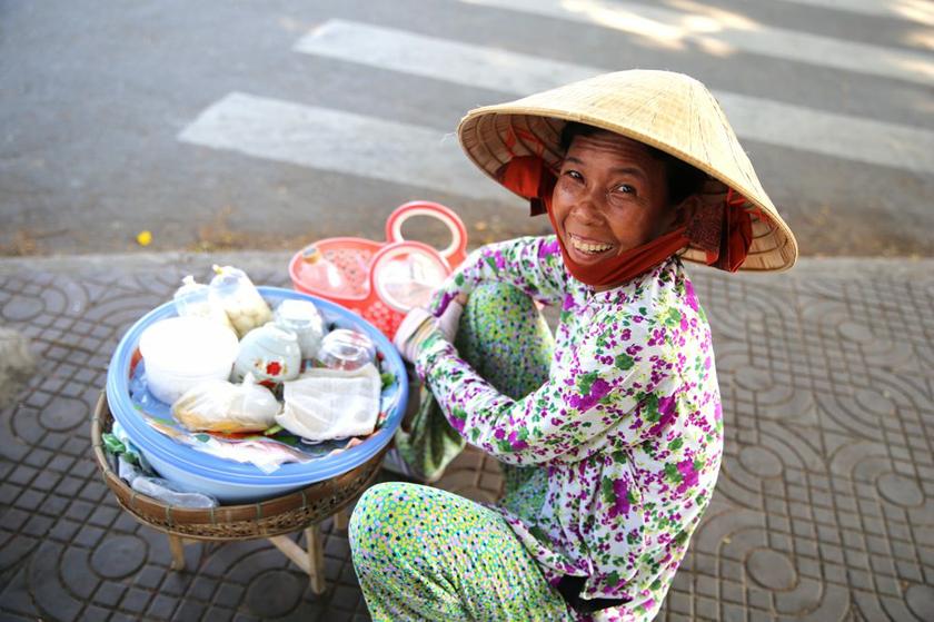 A Vietnamese woman in Rach Gia selling food in a little basket.