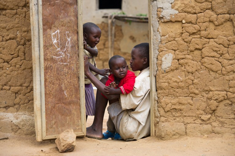 Children from two different families play in the doorway between the two properties in the village of Mbyo, in Rwanda's Eastern Province on March 12, 2014. u00e2u20acu201d AFP pic