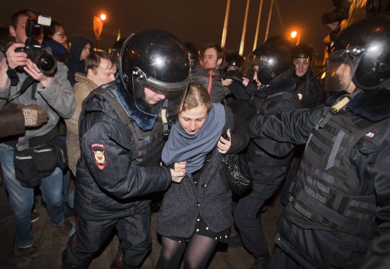 Pussy Riot protester Maria Alyokhina being lead away by security officials may still have to serve a 7 year prison term after being freed recently. u00e2u20acu201d AFP pic