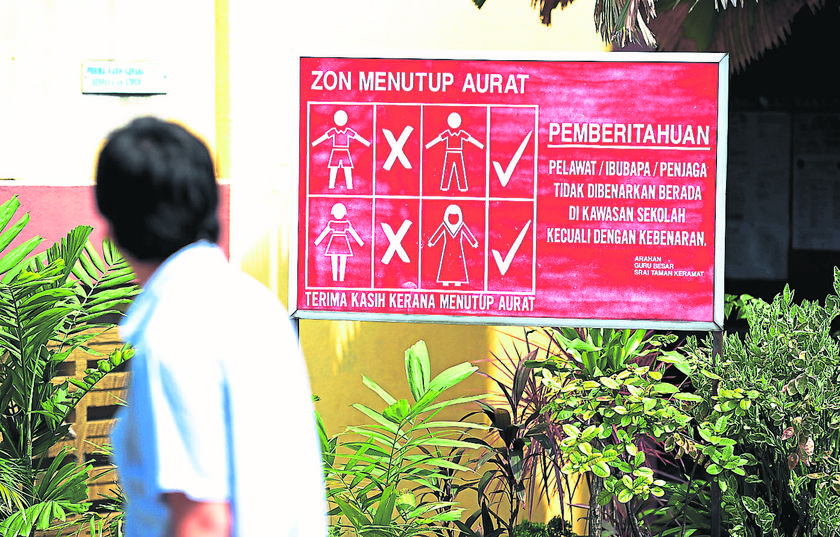 Malay Mail journalist Faizal Nor Izham walks past a sign prohibiting visitors from entering school premises without a pass. u00e2u20acu201d Picture by Azinuddin Ghazali 