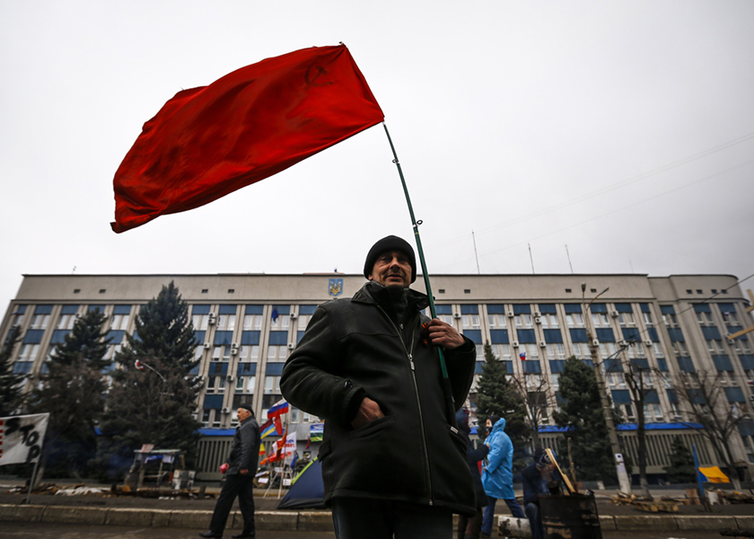 A pro-Russian supporter holds a Soviet flag in front of the seized office of the SBU state security service in Luhansk, in eastern Ukraine, April 13, 2014. u00e2u20acu201d Reuters pic